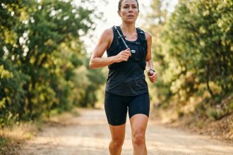 Coureuse d'endurance portant un gilet d'hydratation lors d'une course sur sentier, illustrant l'importance des électrolytes pour les sports d'endurance