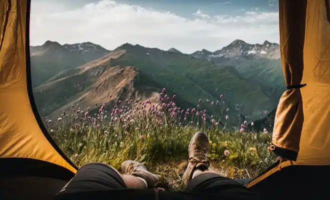 person lying inside tent and overlooking mountain